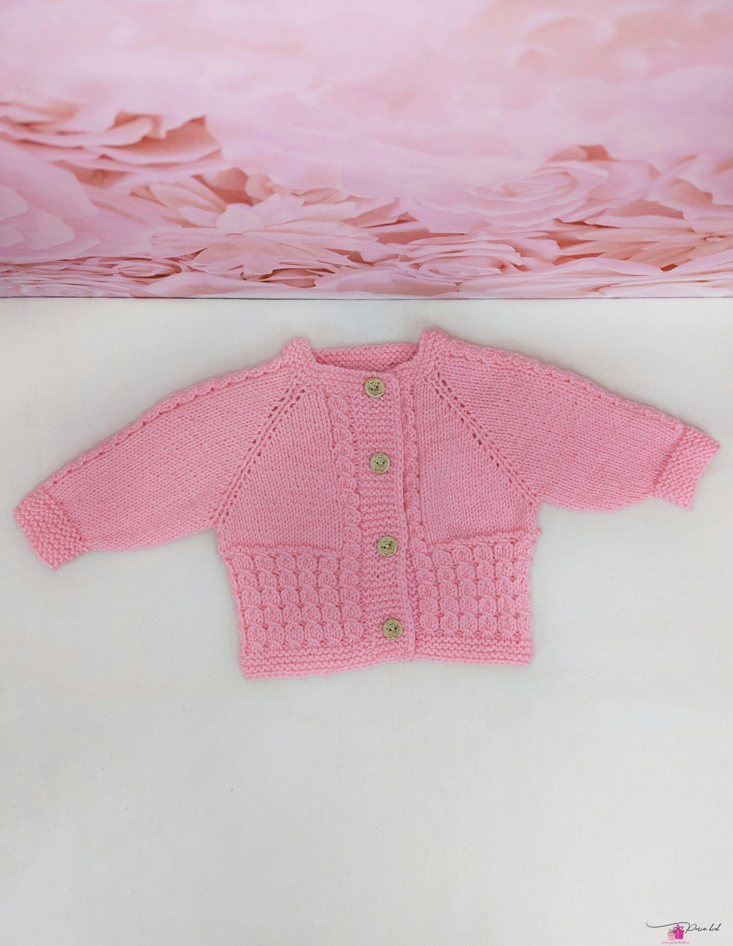 roosa käsitööna kootud kampsun